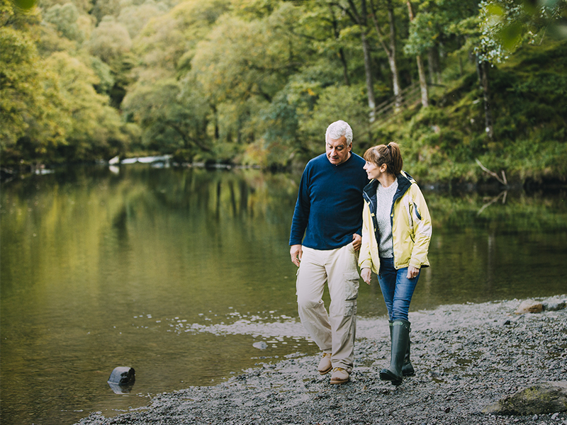 Ein älteres Ehepaar spaziert an einem See